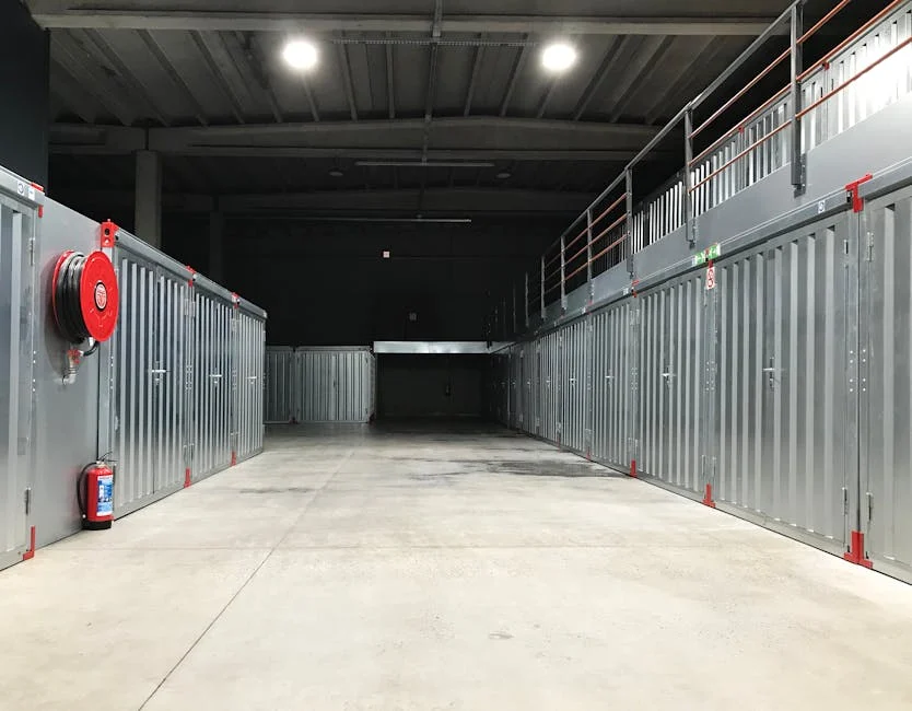 Spacious industrial warehouse interior featuring steel storage units and safety equipment.